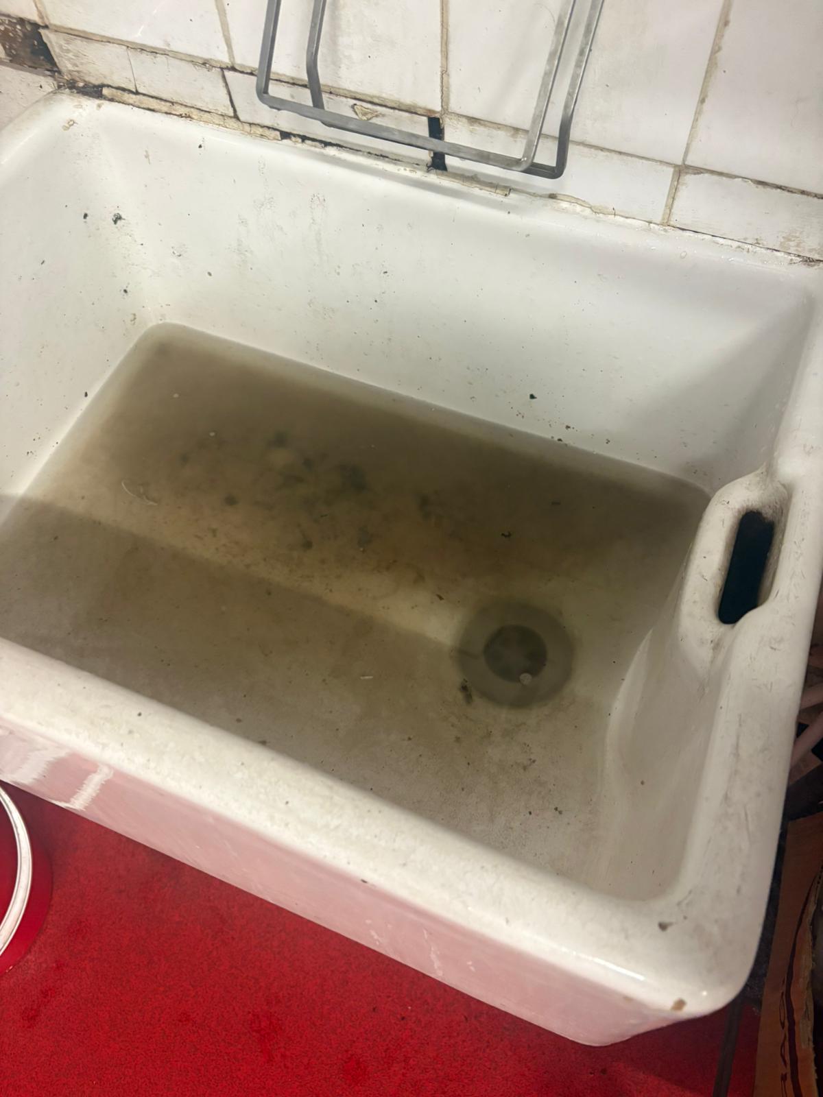 Call2Drain engineer clearing a blocked kitchen sink with standing water in Kent, Surrey, Sussex, Essex & London